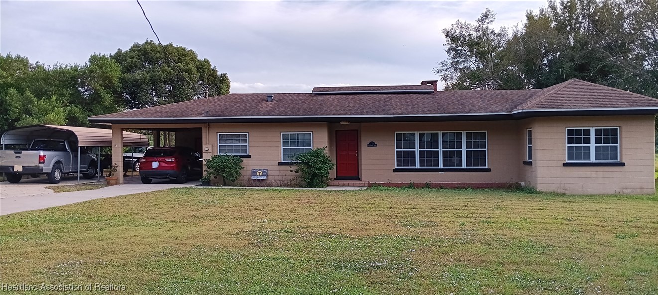 a view of a house with floor to ceiling windows and a yard