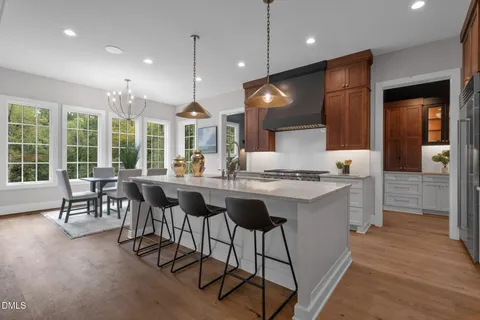 a kitchen with stainless steel appliances kitchen island granite countertop a table chairs sink and microwave