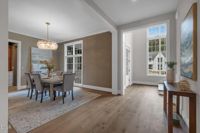 a dining room with wooden floor and a chandelier