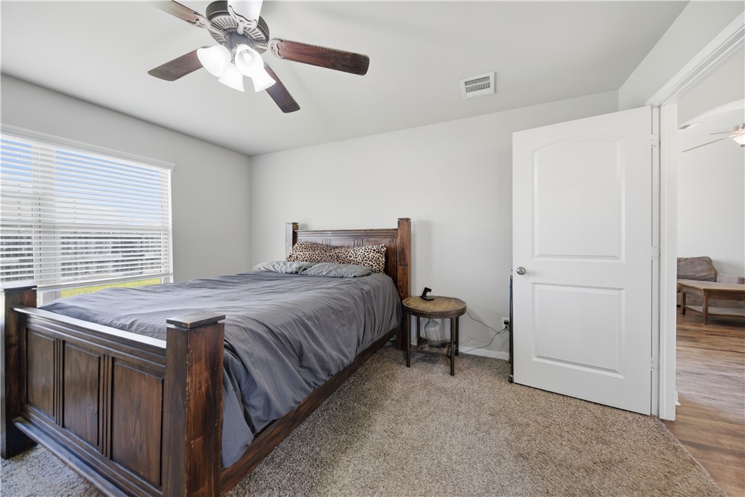 808 Mockingbird Street Navasota, TX 77868 - Photo 12 of 19 a bedroom with a bed and a chandelier