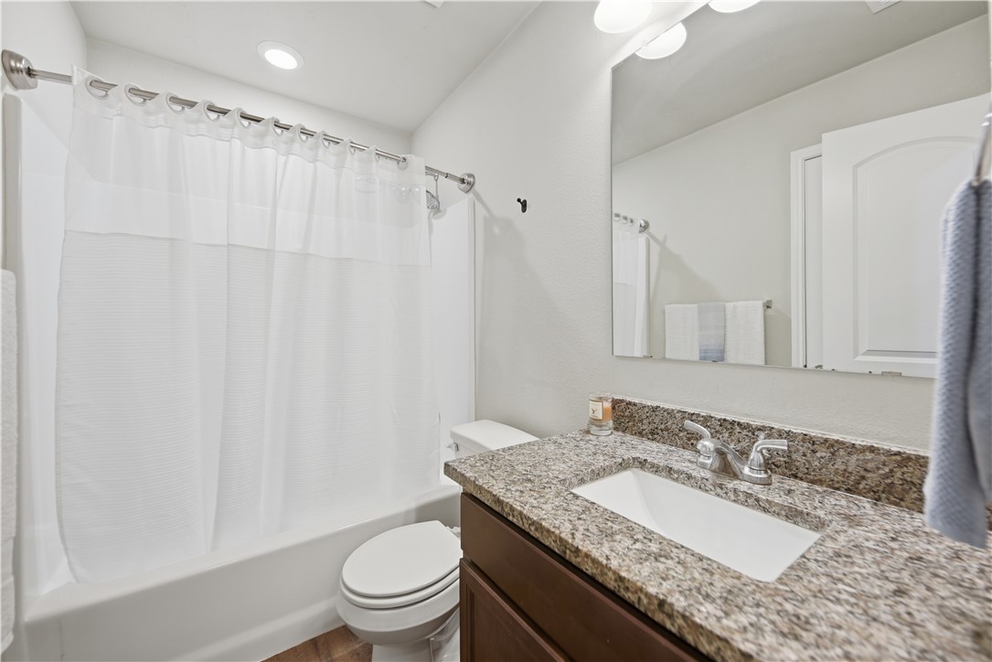 808 Mockingbird Street Navasota, TX 77868 - Photo 13 of 19 a bathroom with a granite countertop sink toilet and shower