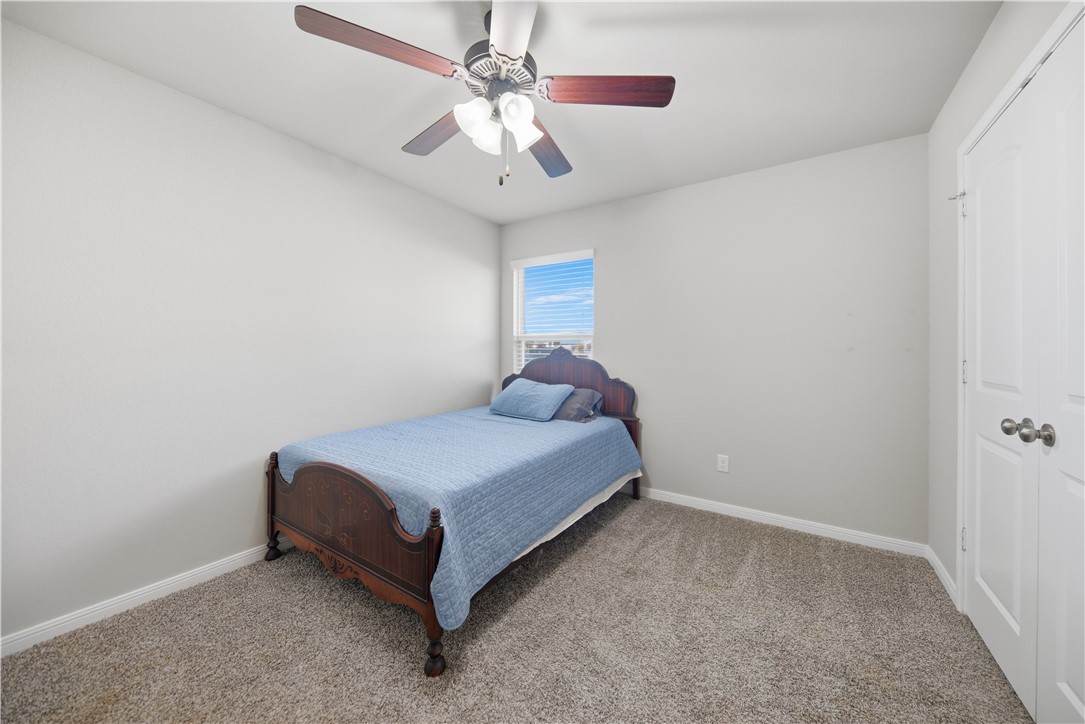 808 Mockingbird Street Navasota, TX 77868 - Photo 14 of 19 a spacious bedroom with a bed and a ceiling fan
