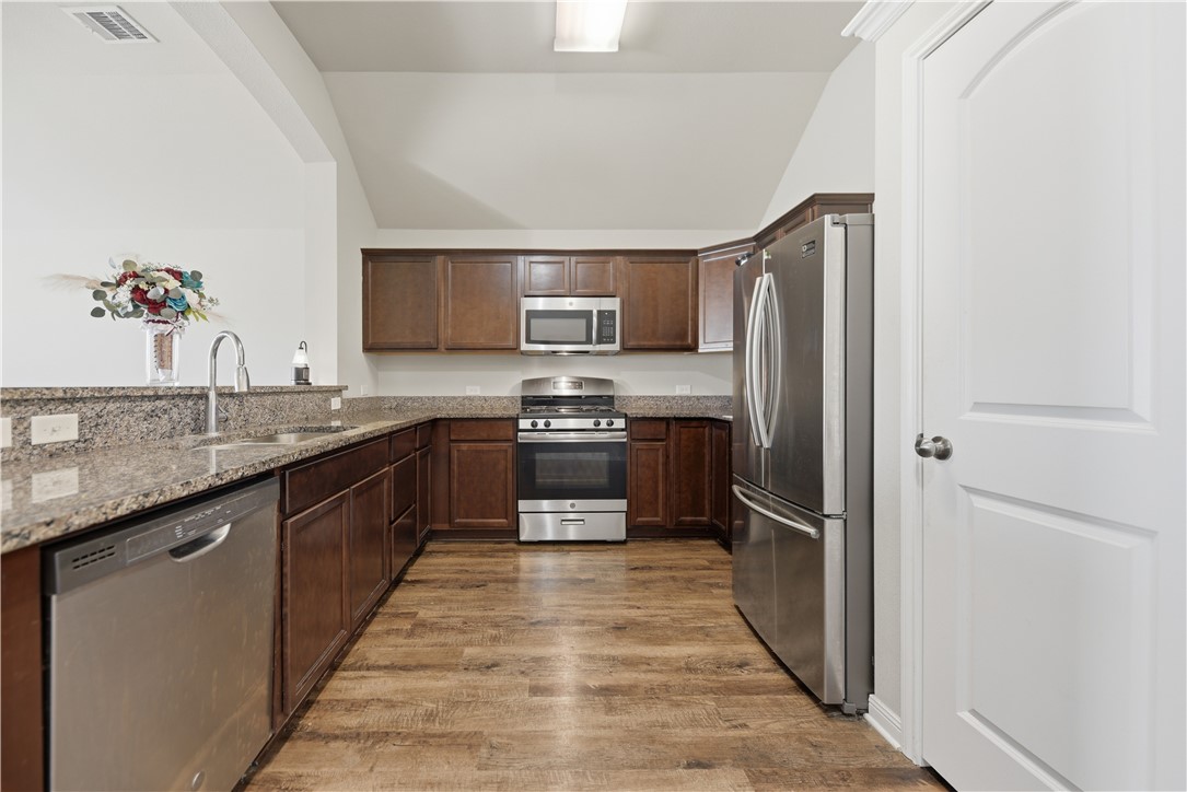 808 Mockingbird Street Navasota, TX 77868 - Photo 7 of 19 a kitchen with stainless steel appliances granite countertop a sink stove and refrigerator