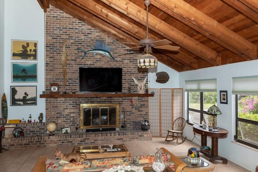 7169 Southeast Rivers Edge Street Jupiter, FL 33458 - Photo 16 of 39 a living room with fireplace furniture a flat screen tv and a fireplace