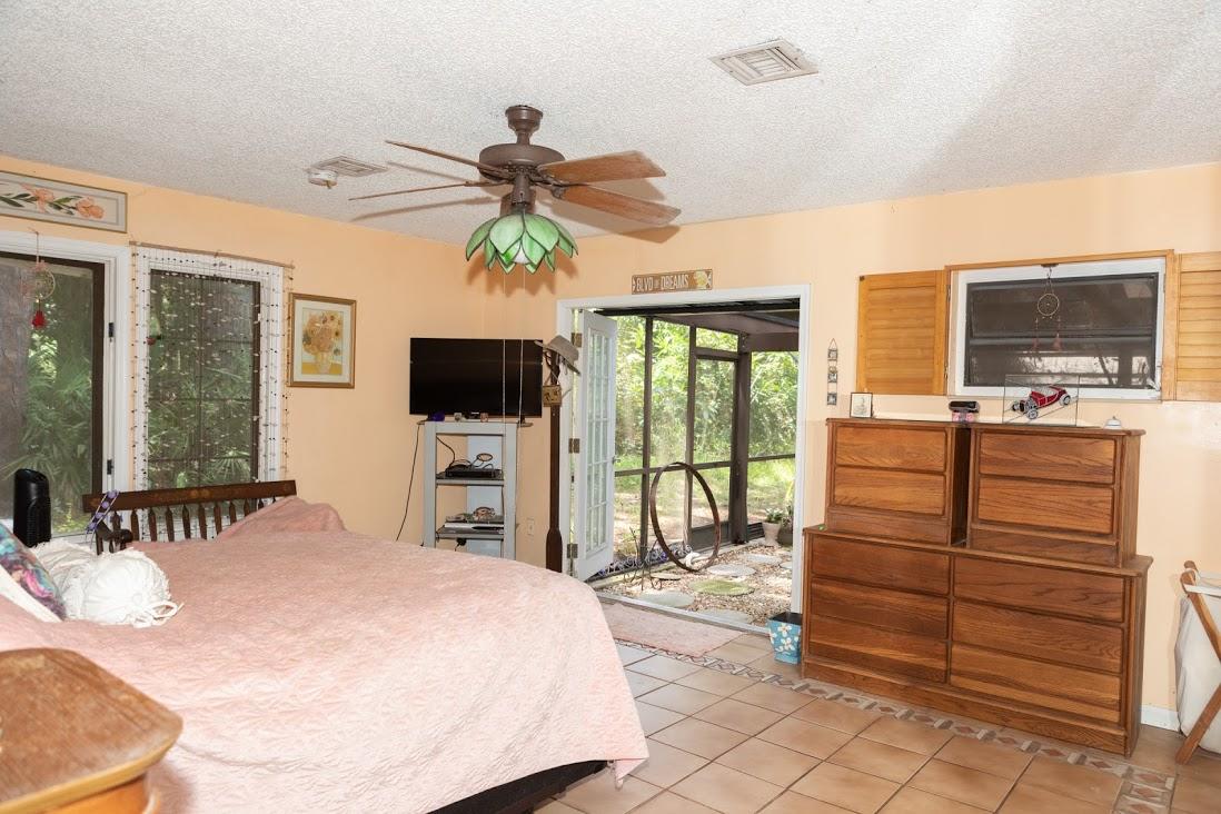 7169 Southeast Rivers Edge Street Jupiter, FL 33458 - Photo 20 of 39 a bedroom with a bed and flat screen tv