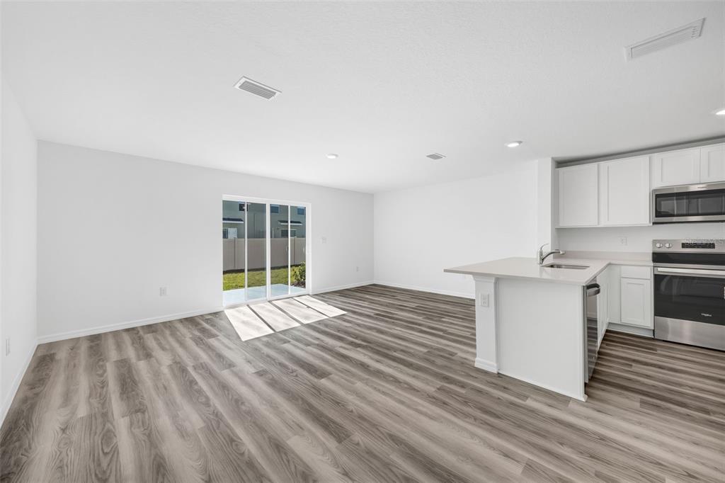 1011 Spotted Egret Loop Ruskin, FL 33570 - Photo 6 of 33 a view of an empty room with a window and wooden floor