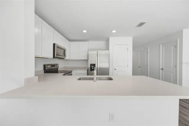 a kitchen with stainless steel appliances a refrigerator sink and stove