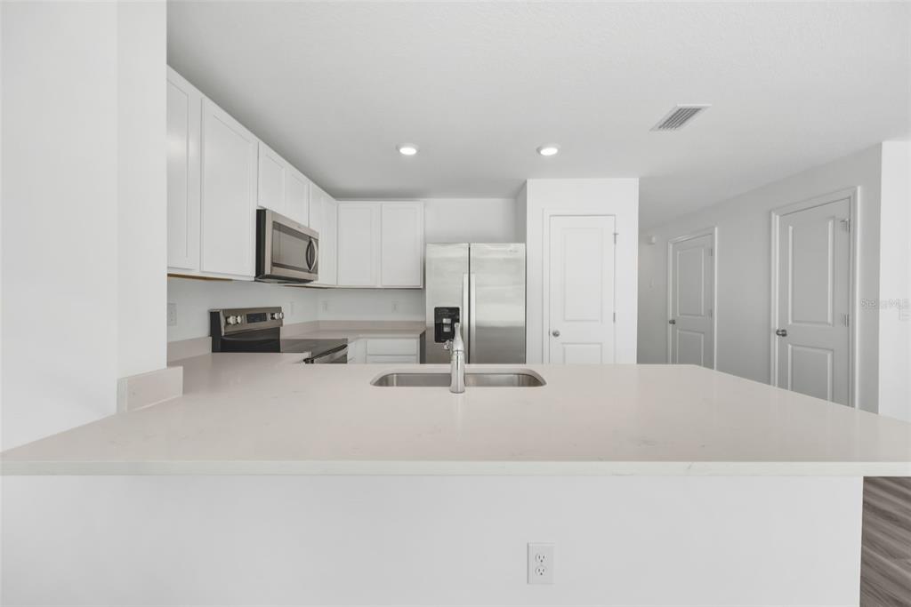 1011 Spotted Egret Loop Ruskin, FL 33570 - Photo 7 of 33 a large kitchen with kitchen island a sink a stove a refrigerator and a refrigerator