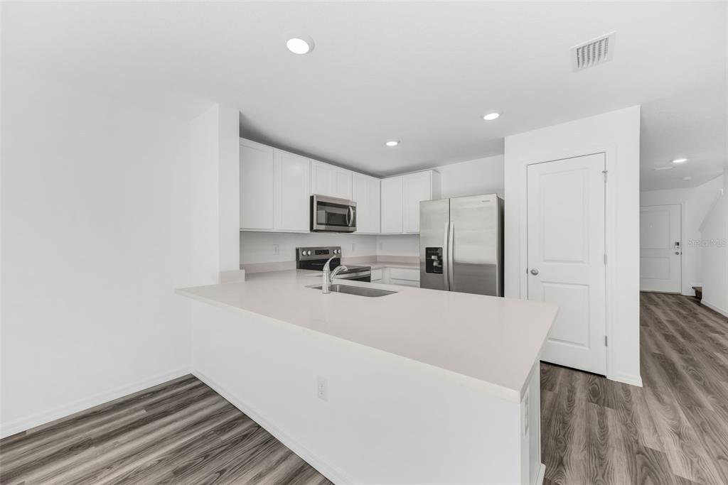 1011 Spotted Egret Loop Ruskin, FL 33570 - Photo 8 of 33 a kitchen with stainless steel appliances a refrigerator sink and stove