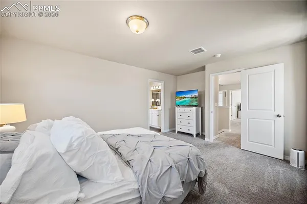 a bedroom with a large bed and a chandelier
