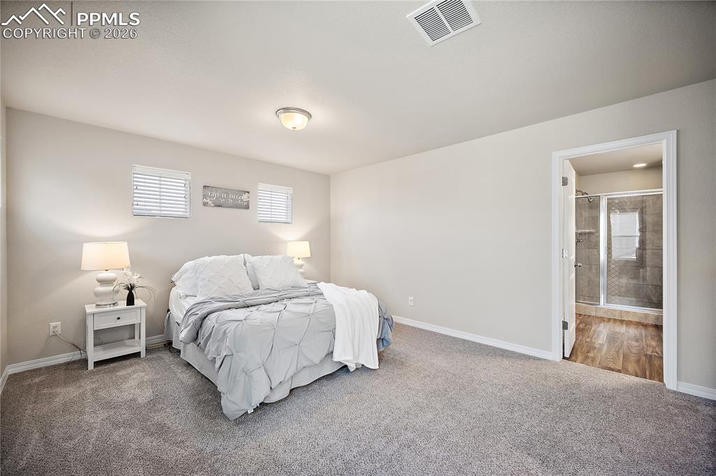 4295 Samaritan Loop Colorado Springs, CO 80916 - Photo 22 of 50 a bedroom with a bed and a lamp