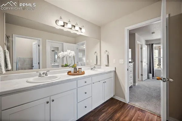 a spacious bathroom with a double vanity sink a mirror and shower