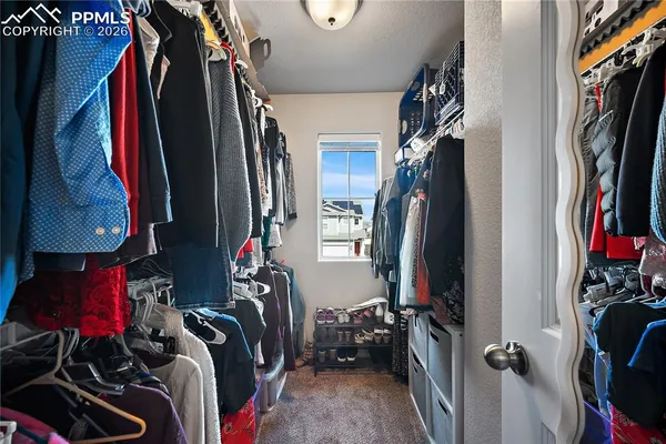 a view of walk in closet with clothes and shoes