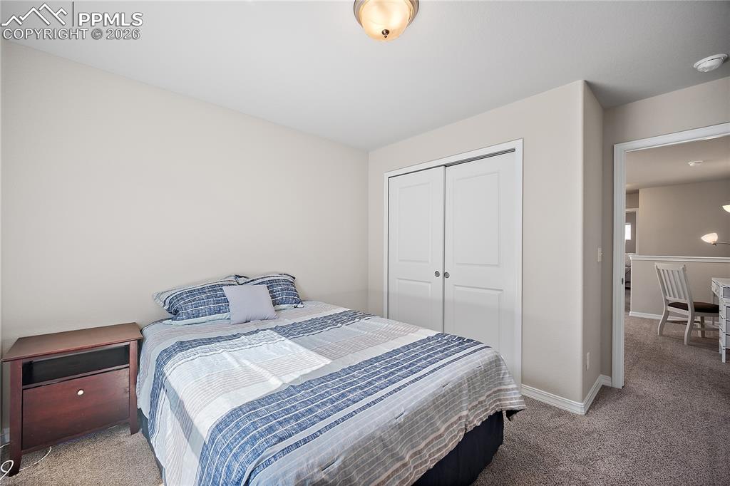 4295 Samaritan Loop Colorado Springs, CO 80916 - Photo 27 of 50 a bedroom with a bed and a chandelier