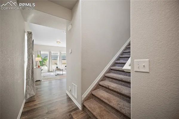 a view of a hallway with wooden floor and staircase