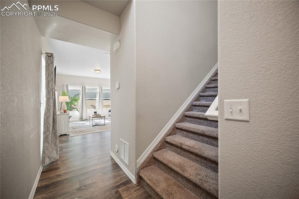 4295 Samaritan Loop Colorado Springs, CO 80916 - Photo 5 of 50 a view of a hallway with wooden floor and staircase