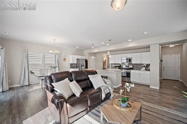 a living room with furniture and kitchen view