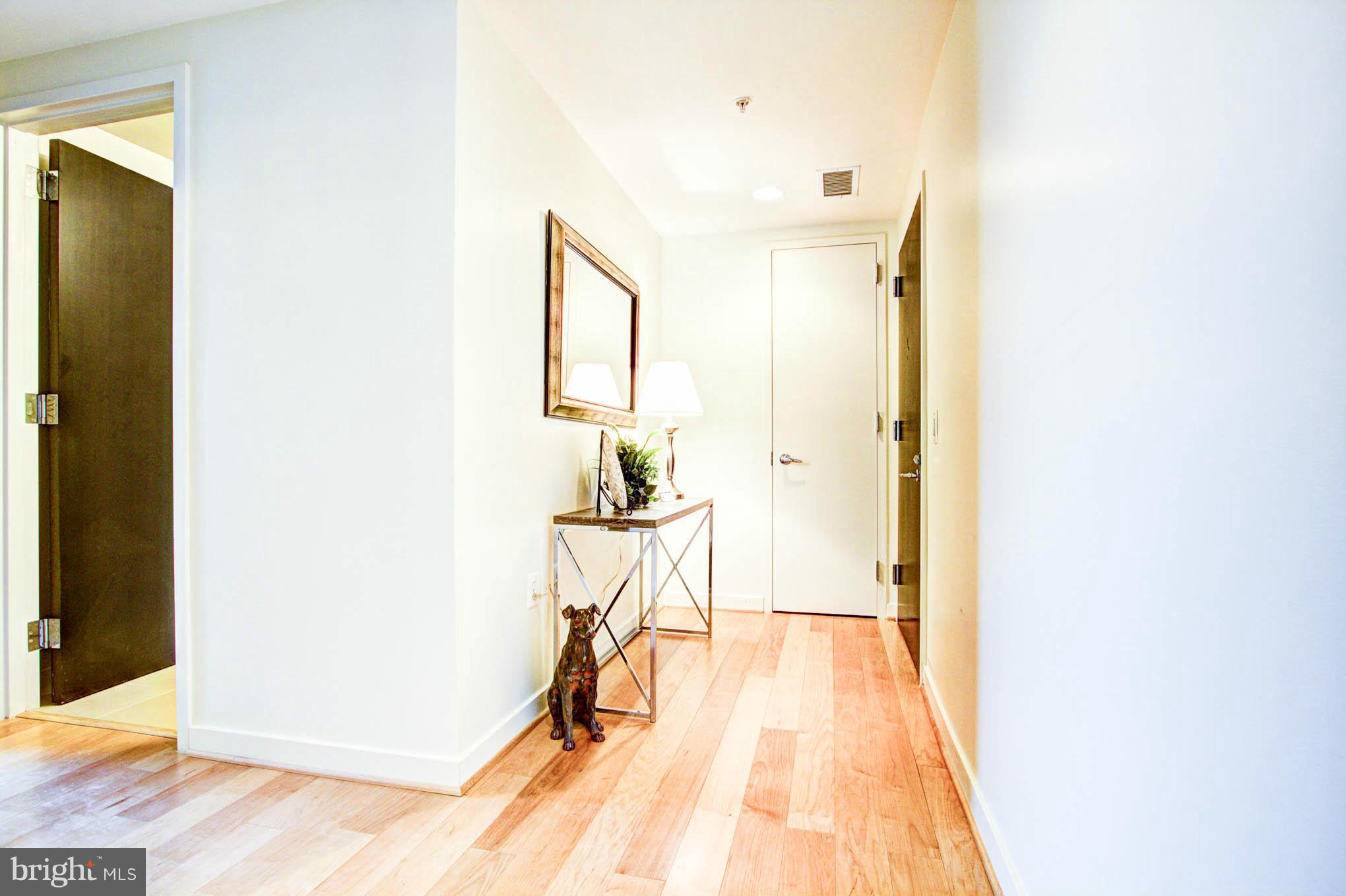 12025 New Dominion Parkway, Unit LL103 Reston, VA 20190 - Photo 2 of 30 a view of a hallway with wooden floor and a bathroom