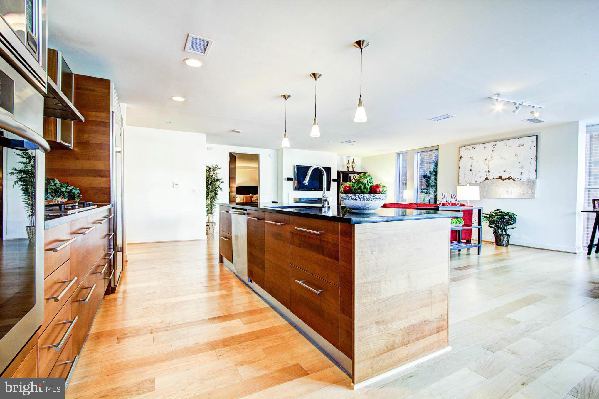 12025 New Dominion Parkway, Unit LL103 Reston, VA 20190 - Photo 14 of 30 a kitchen with stainless steel appliances kitchen island granite countertop a refrigerator a oven and a sink with cabinets
