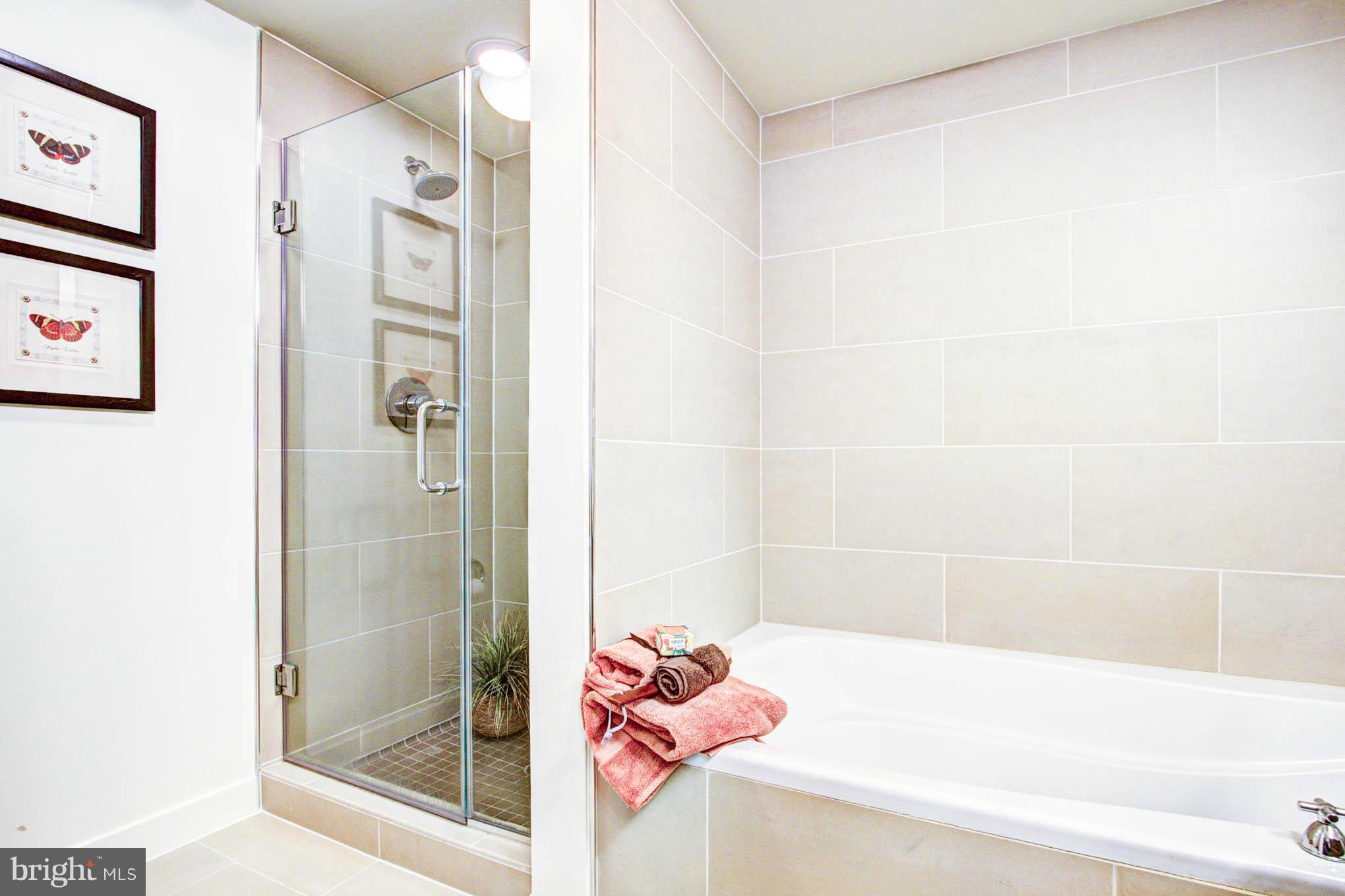 12025 New Dominion Parkway, Unit LL103 Reston, VA 20190 - Photo 20 of 30 a bathroom with a tub shower and a sink