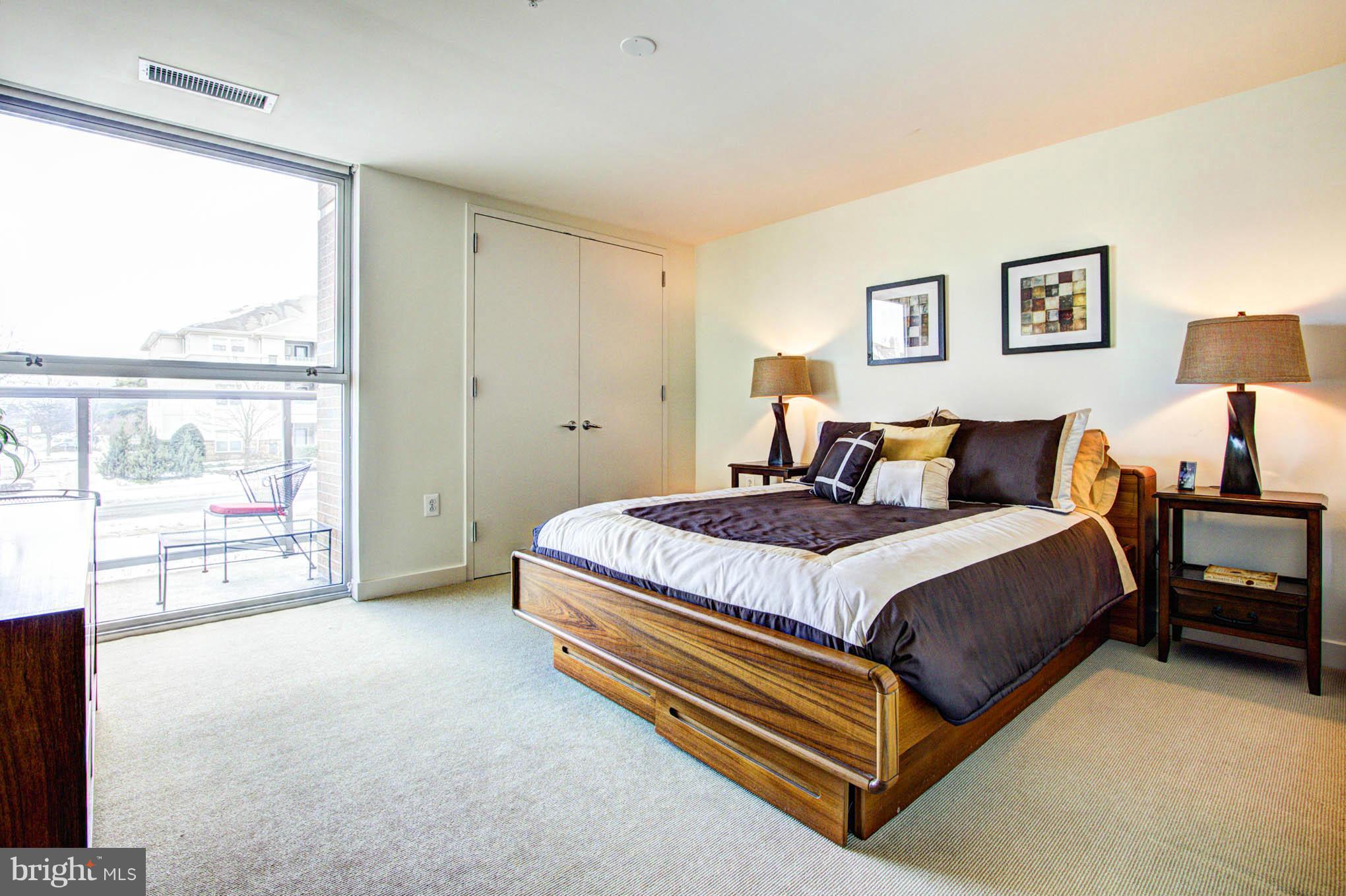 12025 New Dominion Parkway, Unit LL103 Reston, VA 20190 - Photo 3 of 30 a spacious bedroom with a bed and large window