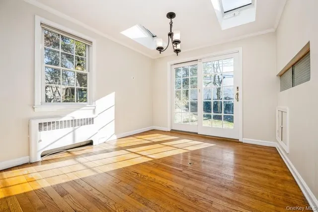 a view of a bedroom with wooden floor and windows