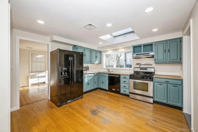 a kitchen with granite countertop a refrigerator and a stove top oven