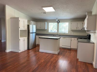 a kitchen with stainless steel appliances granite countertop a refrigerator a sink dishwasher a stove top oven a refrigerator with wooden floors and cabinets