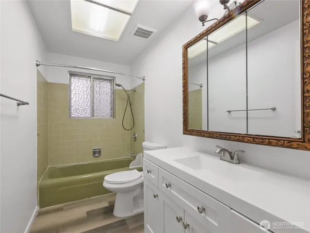 a bathroom with a sink a toilet and a mirror