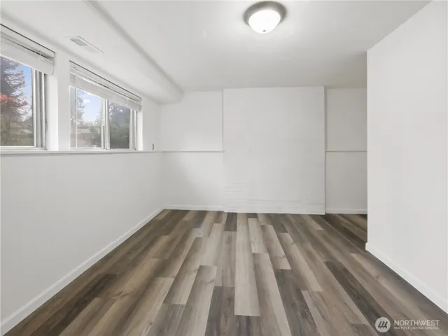 a view of empty room with wooden floor