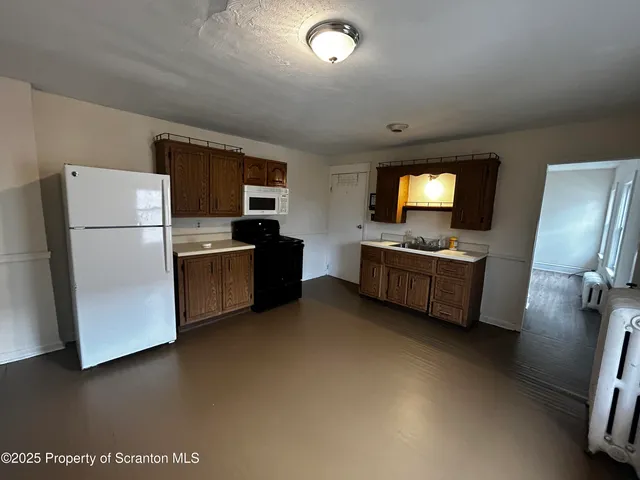 a kitchen with refrigerator and microwave