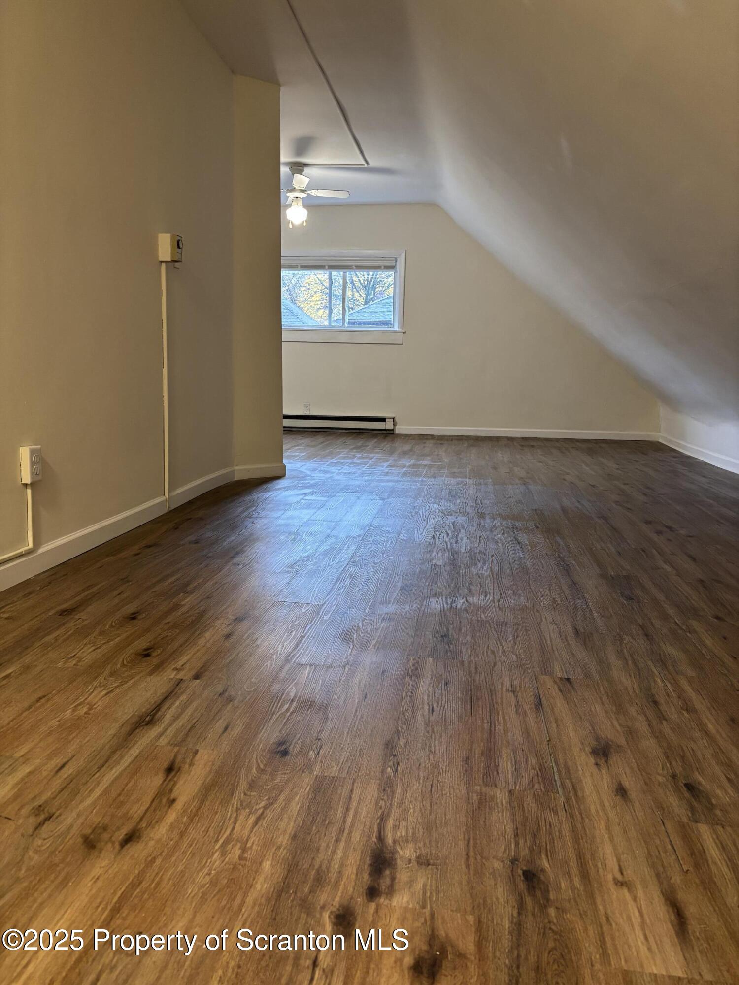 1115 Monroe Avenue, Unit 2 Dunmore, PA 18509 - Photo 6 of 9 an empty room with wooden floor and windows