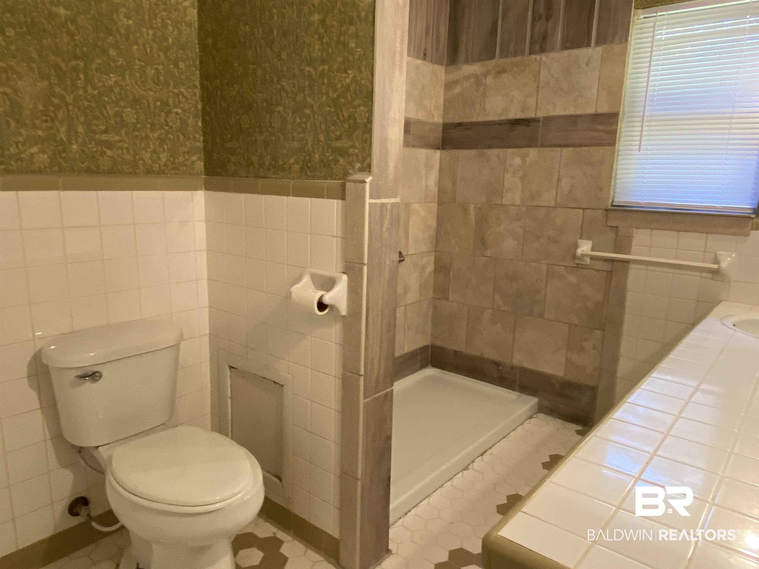 106 Terry Drive Brewton, AL 36426 - Photo 19 of 25 Full bathroom featuring a shower stall, tile walls, and wallpapered walls