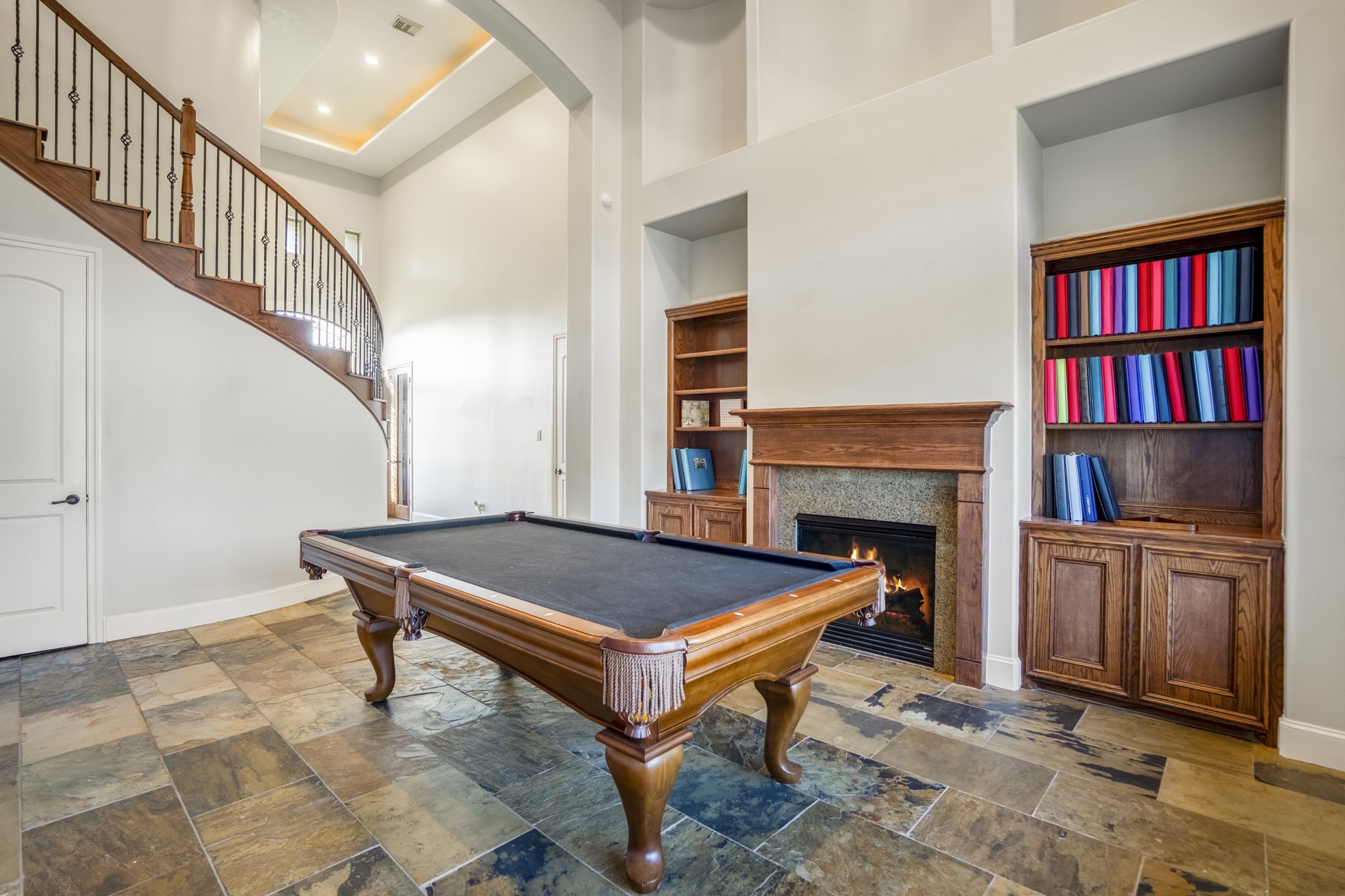 25606 Windy Isle Court Spring, TX 77389 - Photo 12 of 45 A classic fireplace with a warm wood mantel provides a cozy focal point, flanked by built-in bookshelves offering an easy organized display area.