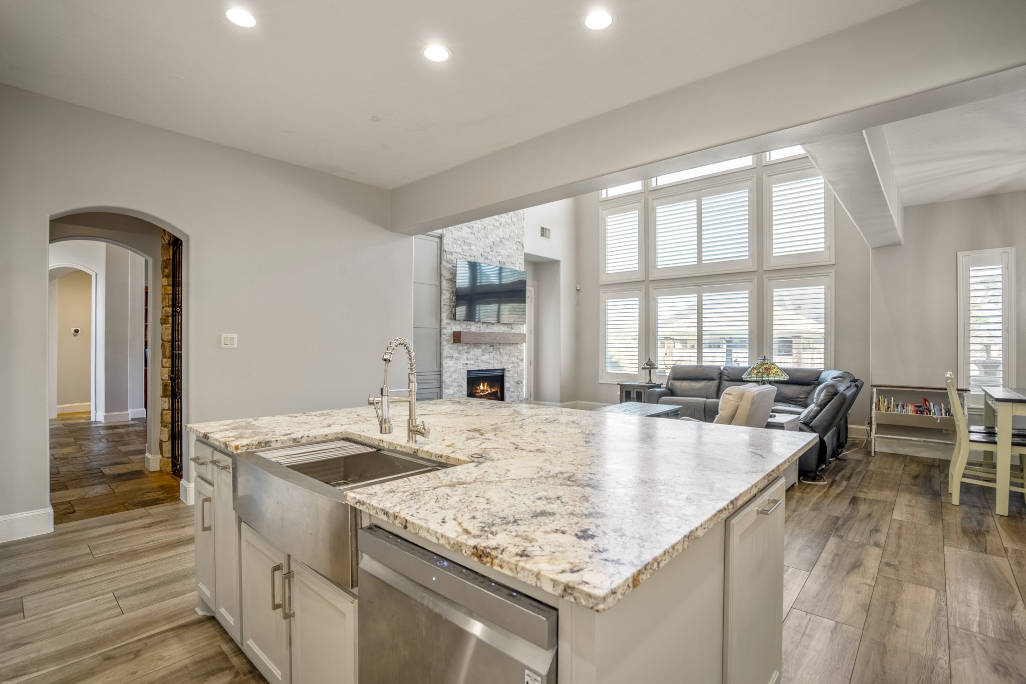 25606 Windy Isle Court Spring, TX 77389 - Photo 17 of 45 The updated kitchen has wood look tile flooring, quartz countertops, large island, and an oversized stainless steel farmhouse sink.