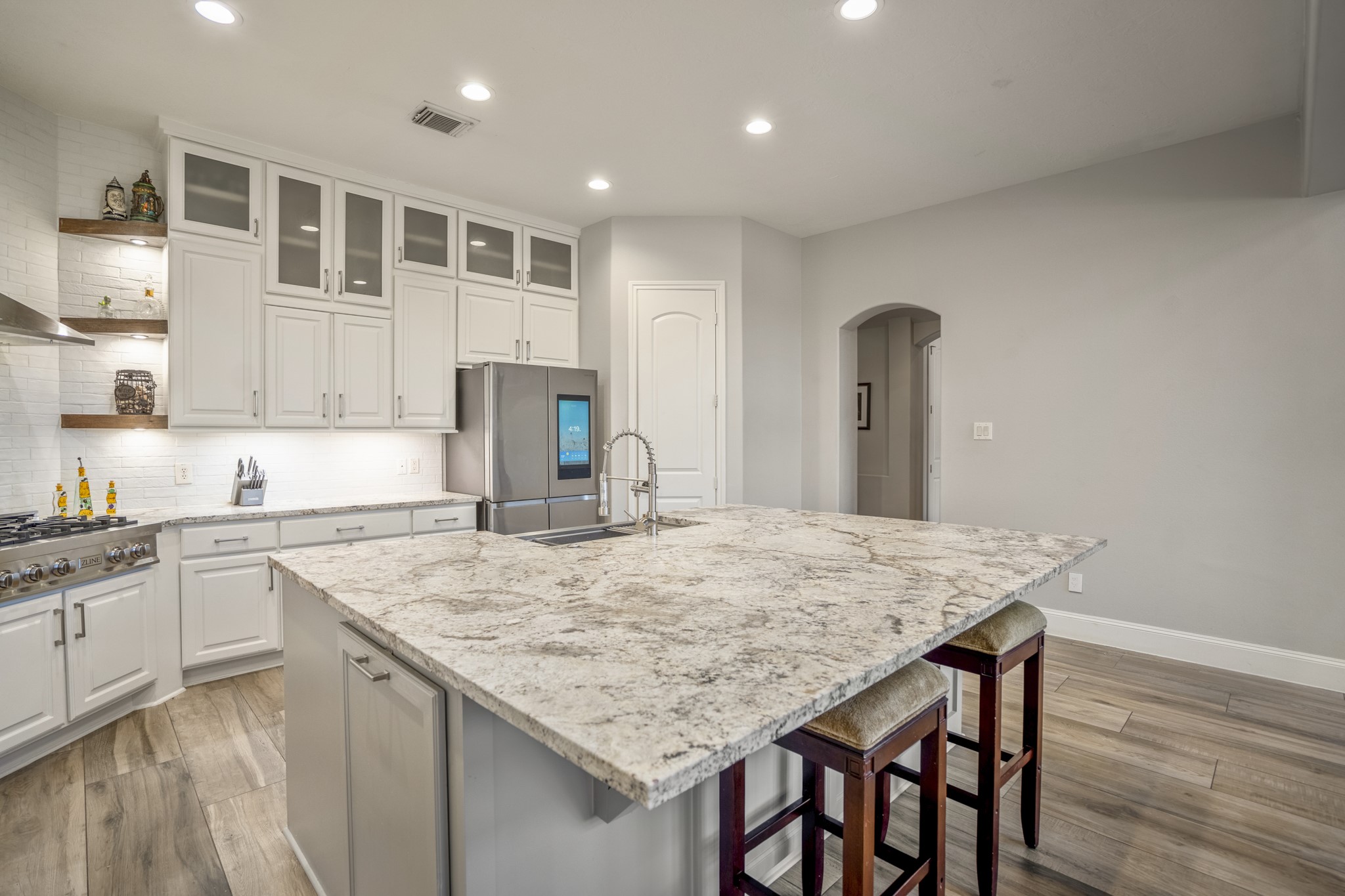 25606 Windy Isle Court Spring, TX 77389 - Photo 18 of 45 Stunning shaker-style white cabinetry extends to the ceiling, complemented by elegant quartz countertops and a clean white tiled backsplash for a timeless look.