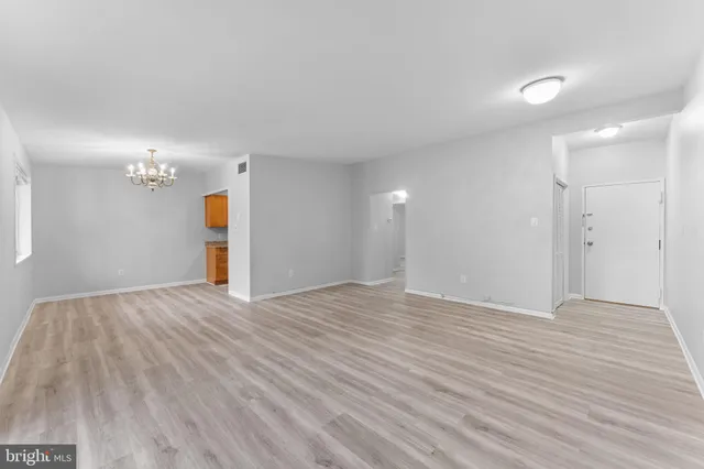 a view of a hallway with wooden floor and closet