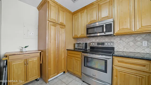 a kitchen with granite countertop cabinets stainless steel appliances and a sink