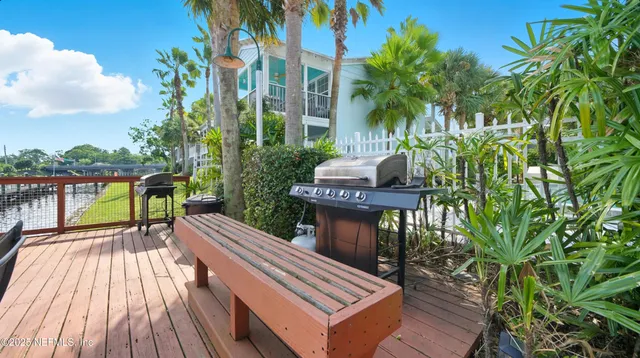 a balcony with wooden floor table and chairs