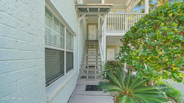 a view of a pathway of a house with potted plants