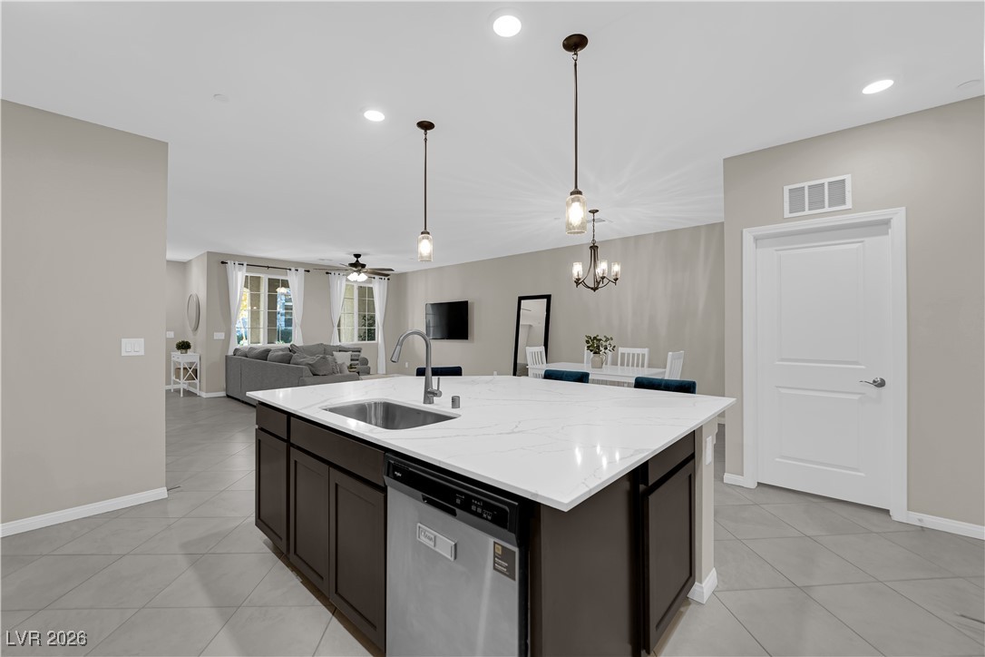 2606 Ercolano Street Henderson, NV 89044 - Photo 11 of 46 Modern kitchen w/ex-large quartz countertops, island w/breakfast bar, espresso cabinets, pendant lights, SS appliances, subway tile backsplash, tile floors & pantry.