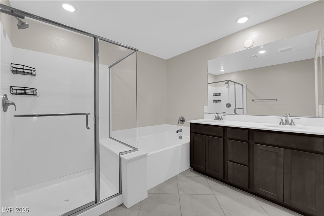 2606 Ercolano Street Henderson, NV 89044 - Photo 25 of 46 Primary bath w/espresso cabinets, quartz counters, dual sinks and sep tub & shower.