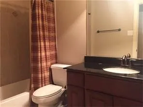 a bathroom with a granite countertop toilet sink and a mirror