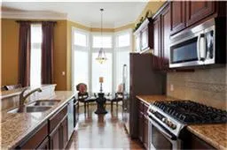 a kitchen with stainless steel appliances granite countertop a stove a sink and a microwave