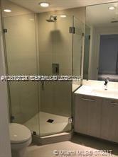 55 Southwest 9th Street, Unit 2504 Miami, FL 33130 - Photo 5 of 29 a bathroom with a granite countertop sink mirror and toilet