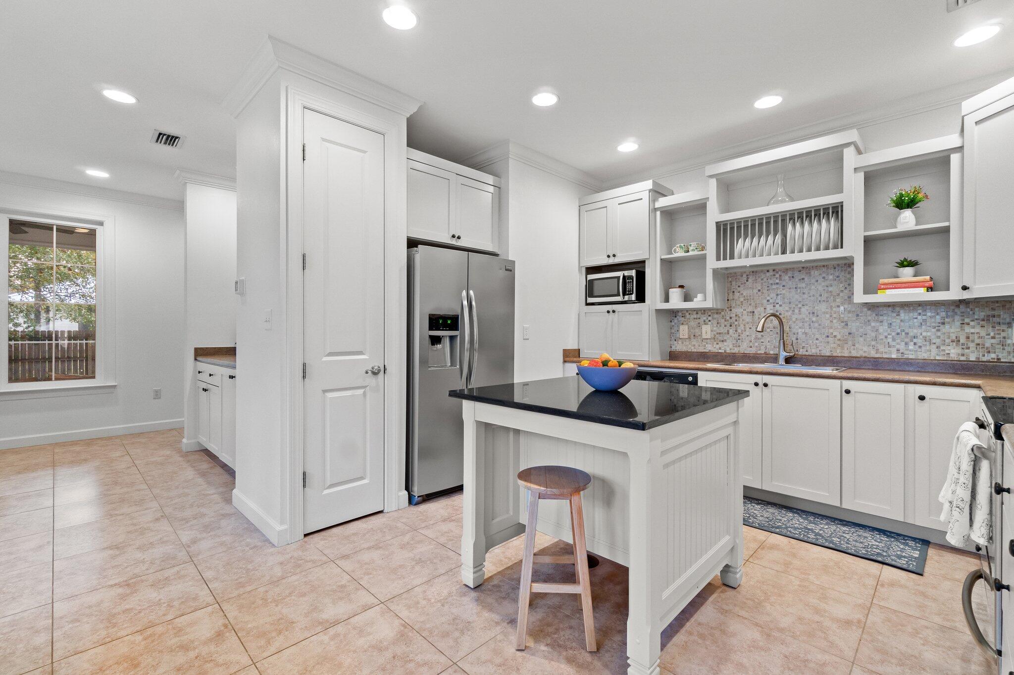 124 East Wild Blueberry Way Santa Rosa Beach, FL 32459 - Photo 12 of 38 a kitchen with stainless steel appliances granite countertop a refrigerator oven a sink a stove and white cabinets