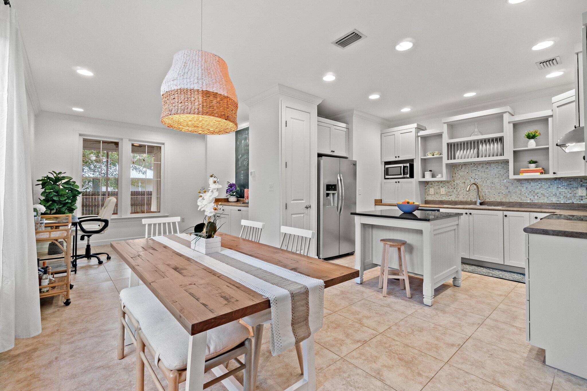 124 East Wild Blueberry Way Santa Rosa Beach, FL 32459 - Photo 2 of 38 a open kitchen with kitchen island a stove a table and chairs in it