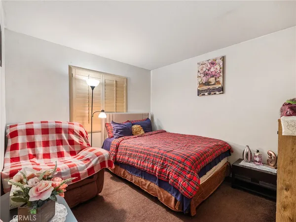 a bedroom with a bed and a lamp on dresser