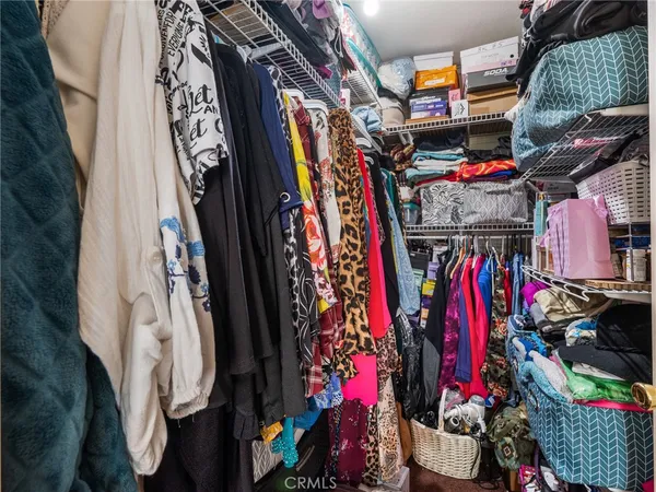 a view of walk in closet with clothes