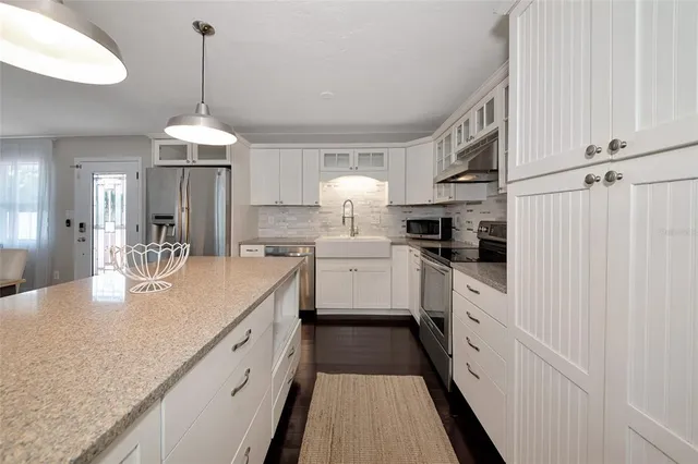 a kitchen with stainless steel appliances granite countertop a sink stove and refrigerator